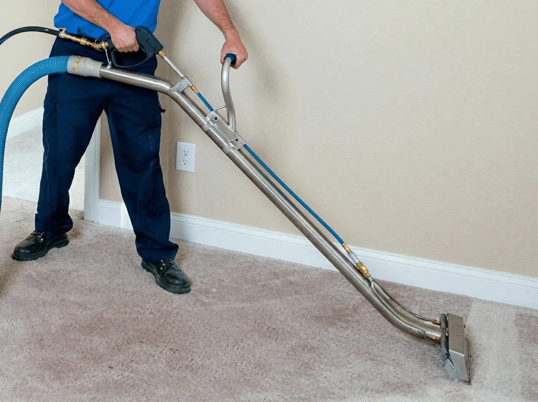 Professional operating a liquid removal machine on a carpeted floor in Glendale, AZ